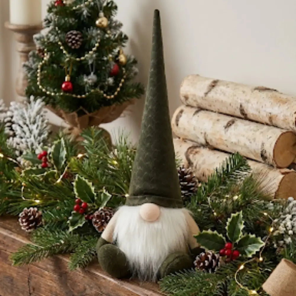 Gnomo navideño con gorro sentado